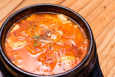 Kimchi çorbası sıcak, siyah tencerede, Kore geleneksel kimchi jjigae çorbası restoranda, Japon sıcak yemeği.