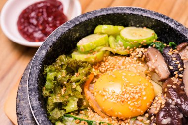 Bibimbap siyah ısıtılmış taş kasede, Kore geleneksel yemeği - bibibimbap sebze ile karışık pirinç sığır eti ve kızarmış yumurta, Japon sıcak tenceresi