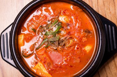 Kimchi çorbası sıcak, siyah tencerede, Kore geleneksel kimchi jjigae çorbası restoranda, Japon sıcak yemeği.