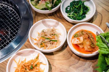 Baharatlı Kimçi grubu. Kore turşusu ya da turşu turşusu sebze seti ve sobanın üzerine baharat, ahşap masa arka planı, Japon yemeği.