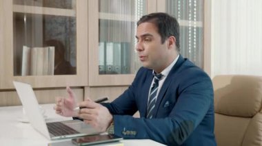 İş adamı, bilgisayarını kullanarak bilgisayarla konferans yapıyor, iş arkadaşlarıyla masaya oturuyor, sohbet eden mutlu bir adam çevrimiçi video konferansına katılıyor, sanal toplantı uzaktan kumandası ofiste çalışıyor.