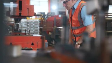Güvenlik giysisi giyen mühendis veya operatör atölyede metal levhaları kağıt bükme makinesi, metal katlama makinesi fabrikasında çalışan, fabrikada çalışan...