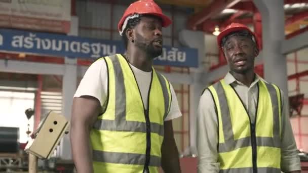 工程人员和走路的工人摘下安全帽 在金属板屋顶制造厂完成工作后一起交谈 — 图库视频影像