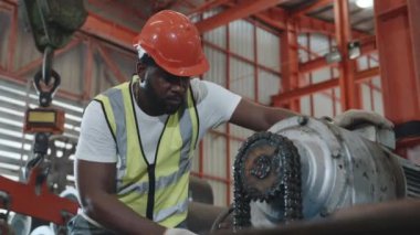 Endüstriyel fabrikada makinenin bakımını yapan bir güvenlik elbisesi giyen mühendis veya operatör, servis teknisyeni, metal levha fabrikasındaki fındık onarım makinesini sıkılaştırın.