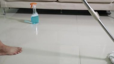Asyalı bir kadın evde paspas ve bez parçasıyla yerleri yıkıyor, ev hanımı evinde yerleri paspaslıyor, evini temizliyor, profesyonel temizlik konsepti.
