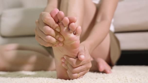 Bolest nohou, Asijky pocit bolesti nohou doma, ženy trpí bolestí nohou pomocí ruční masáže uvolnit svaly z podešví v interiéru domova, Zdravotní problémy a podiatrie lékařské koncepce