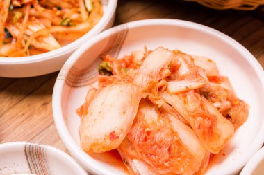 Baharatlı Kimchi. Kore turşusu ya da turp turşusu ve ahşap masa zemininde baharat, Japon yemeği.