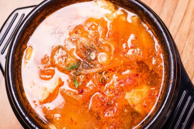 Kimchi çorbası sıcak, siyah tencerede, Kore geleneksel kimchi jjigae çorbası restoranda, Japon sıcak yemeği.