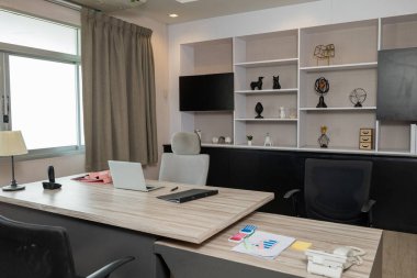 Laptop bilgisayarlı ahşap masanın yanında rahat bir ofis sandalyesi ofis masasının içinde çalışma odası, kimse boş kalmasın.