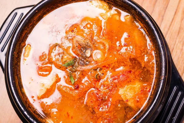 Kimchi çorbası sıcak, siyah tencerede, Kore geleneksel kimchi jjigae çorbası restoranda, Japon sıcak yemeği.