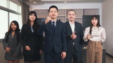 İşletme ekibi işaret işareti gösteriyor ve kameraya bakıyor, iş adamlarından oluşan mutlu bir grup başarılı olma işareti gösteriyor, iş adamları ofiste mutlu bir gülümseme sergiliyor.
