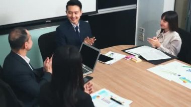 İş adamları birlikte çalışacaklarına ve iletişim kuracaklarına ve alkışlayacaklarına güveniyorlardı. Başarılarını alkışlıyorlardı. Ofisteki toplantı odasında mutlu ve gülümsüyorlardı.