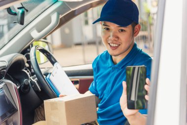 Asyalı kurye çevrimiçi teslimat kutularını arabanın içinde tutuyor ve teslimat için müşteriyle bağlantı kurmak için cep telefonu kontrol yeri kullanıyor, çevrimiçi alışveriş hizmeti kavramları.