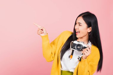 Çekici, enerjik, mutlu bir Asyalı portresi. Güzel, tatlı, genç bir kadın. Elinde eski model fotoğraf makinesiyle heyecanla gülümsüyor.