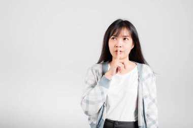 Dudaklarını parmaklarken sessiz, sessiz, mutlu Asyalı, genç, güzel, sessiz, sessiz, sessiz stüdyo çekimleri, beyaz arka planda izole edilmiş, fotokopi çekimleri.