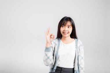 Gülümseyen bir kadın, stüdyo çekiminin izole edilmiş beyaz arkaplan, Mutlu Asyalı portresi güzel genç kadın yaşam tarzı imzası ve fotokopi alanı ile el imzası olduğunu gösteren bir işaret yaptı.