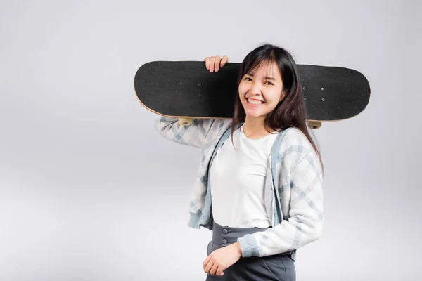 笑顔幸せな女性は肩の上にスケートボードを保持します 幸せなアジアの美しい若い女性励起ホールド手ロングボード スタジオショットコピースペースと白の背景に隔離されました スポーツ極端な — ストック写真