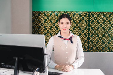 Mutlu genç personel havaalanı kontrolü gülümseme ve tezgah masasında durmak, kontrol belgeleri pasaport ve triket bekliyor yolcu ile