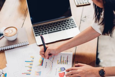 İş kadını kadın yaşam tarzı, dizüstü bilgisayarla çalışıyor ve tavan arası kafeteryasında grafik karını inceliyor. İş kadını, mali istatistik veri analizi grafiğinde kar artışı grafiğine bakıyor.