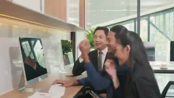 幸せな3つのビジネスグループの人々が興奮し 手を挙げてコンピュータの画面を見てアジアのビジネスチームワークは デスクオフィスで成功したプロジェクト実現の勝利を祝います — ストック動画