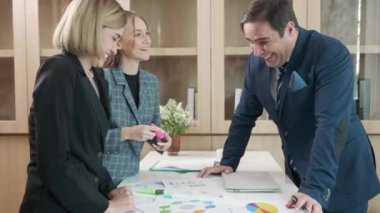 İş ekibi toplantısı, projenin sunumunu sunar. Ofiste gelir tabloları grafikleri, İş Analiz Stratejisi değerlendirme verileri, fikir sunumu ve finansal pazarlama stratejisinin karşılama stratejisi