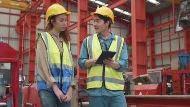 Fabrika müdürü ve işçisi tablet bilgisayarla bir şey tartışıyor, iki etnik çeşitlilikte metal levha endüstriyel işçi buluşuyor ve yeni proje planı, Kalite Kontrol Yönetimi hakkında tartışıyorlar.