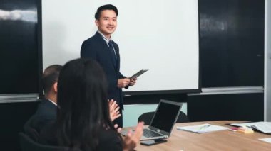 İş adamları birlikte çalışacaklarına ve iletişim kuracaklarına ve alkışlayacaklarına güveniyorlardı. Başarılarını alkışlıyorlardı. Ofisteki toplantı odasında mutlu ve gülümsüyorlardı.