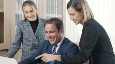 Bir grup genç iş adamı ofiste bir dizüstü bilgisayarla birlikte çalışıyorlar proje ekibi patronla konuşuyor bilgisayarla iş planını tartışmak için mutlu çalışma günleri.