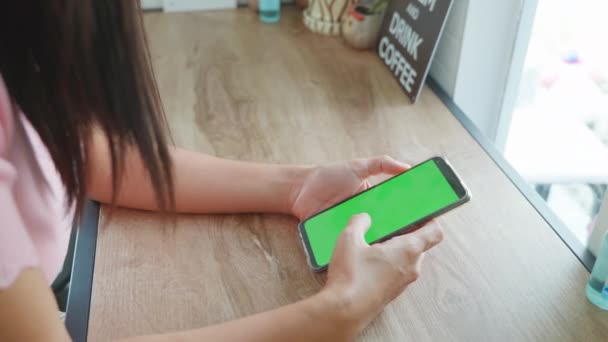 화면으로 핸드폰이나 전화를 여성의 뉴스를 미끄러지는 커피숍에서 미디어를 이용하는 — 비디오