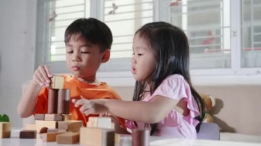 Children boy and girl playing with constructor wooden block building, Happy little kids play wood block stacking board game at home, activities learning creative, toys for preschool and kindergarten