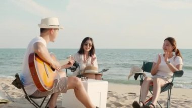Mutlu arkadaş kampta gitar ve alkış çalarken iyi eğlenceler. Tatilde kumsalda birlikte gülümsüyorlar. Gün batımında kamp çadırında tatil yapıyorlar.