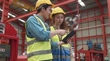 Fabrika müdürü ve işçisi tablet bilgisayarla bir şey tartışıyor, iki etnik çeşitlilikte metal levha endüstriyel işçi buluşuyor ve yeni proje planı, Kalite Kontrol Yönetimi hakkında tartışıyorlar.