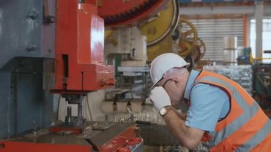 Güvenlik giysisi giyen mühendis veya operatör atölyede metal levhaları kağıt bükme makinesi, metal katlama makinesi fabrikasında çalışan, fabrikada çalışan...