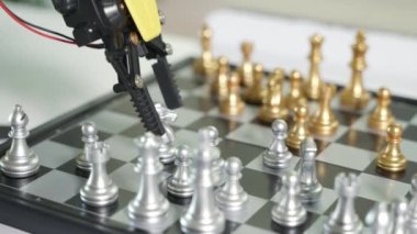 Closeup yellow robot arm playing move chess on chessboard, STEM education E-learning, Technology science robot education concept