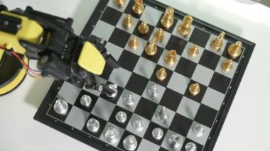 Yakın plan sarı robot kolu satranç tahtasında satranç, BTMM eğitimi E-öğrenme, Teknoloji Bilimi Robot Eğitimi konsepti