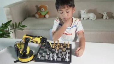 Asyalı küçük çocuk düşünüyor ve bekliyor satranç oynayan robot kolu, BTMM eğitimi E-öğrenen komik çocuklar başarılı bir ders kontrolü robot kolu oyunu, teknoloji bilimi eğitimi konsepti