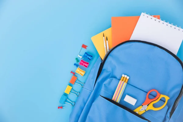 Top view flat lay of blue school bag backpack and accessories tools for children education on blue background, Back to school concept and have copy space for use