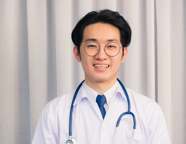 幸せなアジアの若い医師の肖像ハンサムな男は オンラインビデオ会議の呼び出しやカメラを探して顔時間を話して聴診器と一様で笑顔 医療医学の概念 — ストック写真