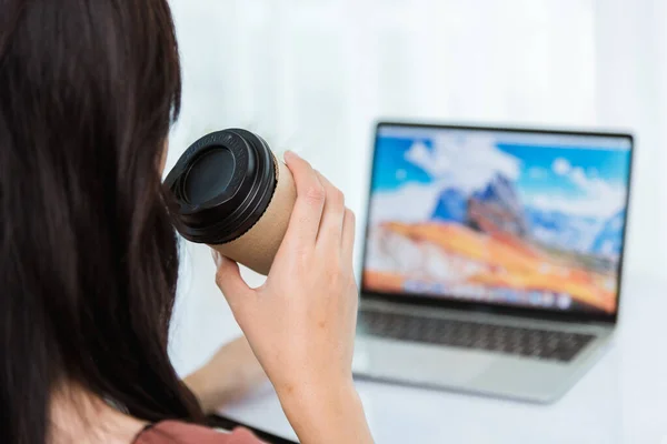 自宅からの仕事 アジアの若いビジネスマンの女性のビデオ会議の呼び出しやFacetimeの会議のバックフロントノートパソコン上のコーヒーカップを保持します — ストック写真