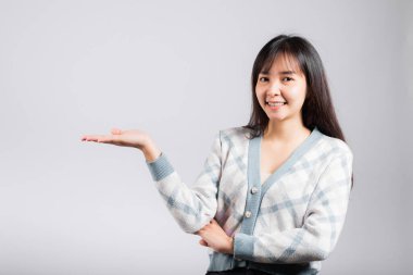 Gülümseyen mutlu kadın avucunun içinde bir şey tutuyor, portre Asyalı güzel genç bayan gösteri eli beyaz arka planda izole edilmiş jest stüdyosu çekimini gösteriyor.