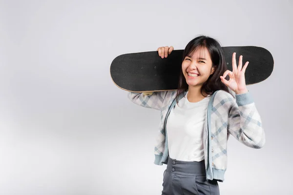 笑顔幸せな女性を保持スケートボード上の肩とショー をサイン 幸せなアジアの美しい若い女性励起ホールド手ロングボード スタジオはコピースペースと白の背景に隔離されたショット — ストック写真