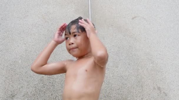 アジアの子供の男の子はスイミングプールリゾートでシャワーを浴びて 幸せな子供彼は家族の夏休みの間に熱帯リゾートで清々しい体と衛生をきれいに泳いだ後 — ストック動画