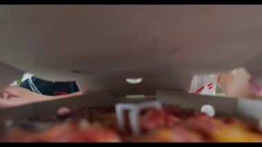 Mutlu iki küçük Asyalı çocuk 5 yıl açık pizza kartonunda ve çok şaşırmış ve mutlu bir şekilde evde, masada çocuklar sağlıksız yiyecekler yiyor heyecanlı komik çocuklar pizza yiyor, kutunun içinde