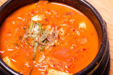 Kimchi çorbası sıcak, siyah tencerede, Kore geleneksel kimchi jjigae çorbası restoranda, Japon sıcak yemeği.