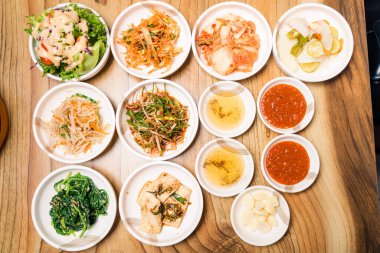 Baharatlı Kimçi grubu. Kore turşusu ya da turp turşusu ve ahşap masa zemininde baharat, Japon yemeği.