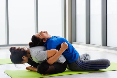 İki Asyalı kadın birlikte yoga dersi alan çekici ve çekici insanlar spor salonunda spor yapıyorlar, genç ve son sınıf bayan egzersizler yoga sınıflarında yoga yapıyorlar, sağlıklı bir yaşam tarzları var.