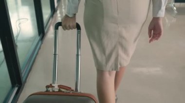 Havaalanı terminalinde bavul taşıyan iş kadını ve hava yolculuğu ve toplantı için bavul, seyahat ve tatil sezonu konsepti taşıyan kadın.