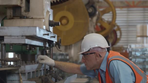 车间穿着安全工作服的工程师或操作员工作时使用板材压弯机 工厂工人在金属折叠机上放置工件 — 图库视频影像