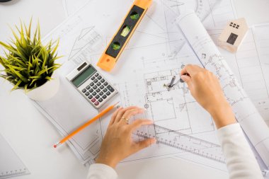 Mimari proje işyeri. İnşaat projesini çizen mühendis, mimarlık bürosundaki masa masasındaki tamir araçları için ev planı taslak kağıdına bölücü pusula çizen mimar.