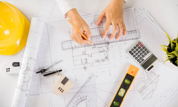 Architectural project workplace. Architect drawing with ruler on house plan blueprint paper for repair tools on table desk at architecture office, architect sketching construction, Engineering tools